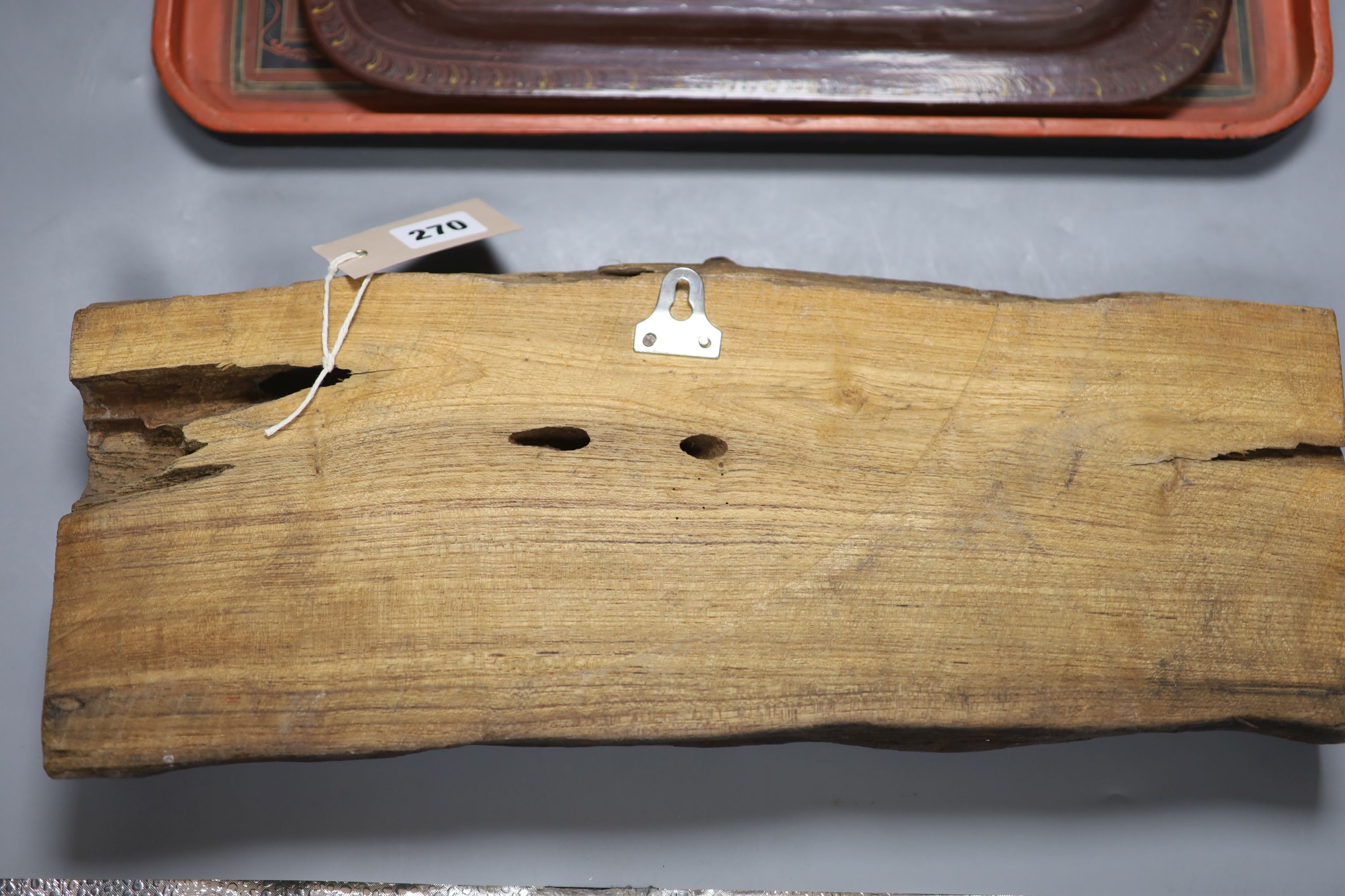 An African hardwood carving of a herd of elephants, and two papier mache trays, largest 46cm